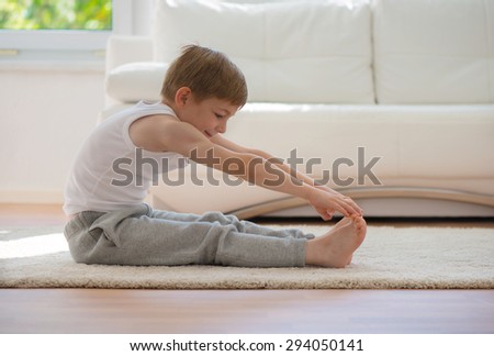 Happy little  boy exercising sport at home
