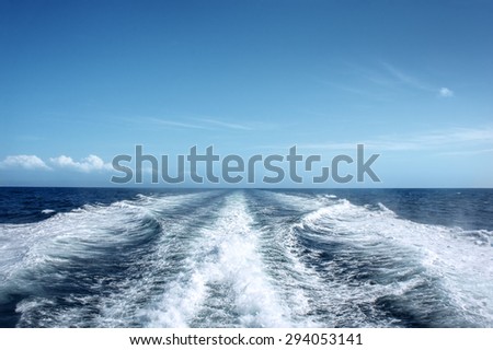 Trail on water surface behind of fast moving motor boat Royalty-Free Stock Photo #294053141