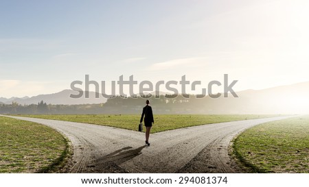 Back view of businesswoman standing on crossroads and making choice Royalty-Free Stock Photo #294081374
