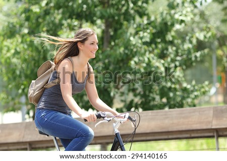 Healthy and happy cyclist woman riding fast a bicycle in a park Royalty-Free Stock Photo #294140165