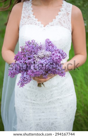beautiful bouquet of lilac flowers in bride's hands