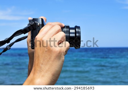 closeup of a young caucasian man taking a picture in front of the sea