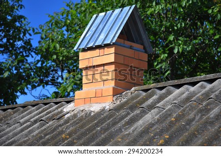 Old asbestos roof with new brick chimney. Roof repair