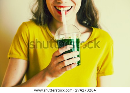 young girl drinking green cocktail with a straw Royalty-Free Stock Photo #294273284