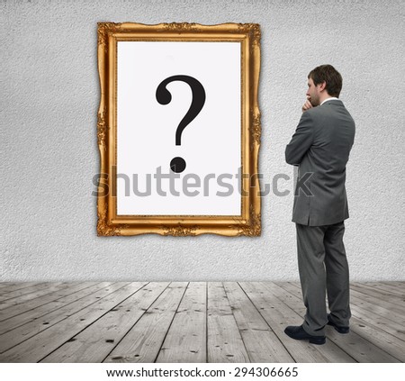 Young Businessman watching the question mark in a gold frame