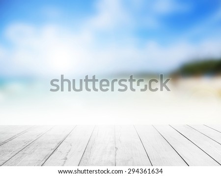 The blur cool sea background with wood floor foreground on horizon tropical sandy beach; relaxing outdoors vacation with heavenly mind view at a resort deck touching sunshine, sky surf summer clouds. Royalty-Free Stock Photo #294361634