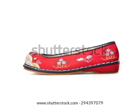 Pair of pretty colorful red Korean rubber shoes with blue toe caps and a gold floral decoration in a classic court shoe design on a white background