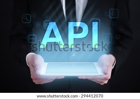 Businessman holding a tablet pc with "API" text on virtual screen. Internet concept. Business concept.