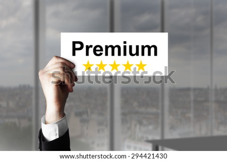 businessmans hand holding up small sign premium five stars