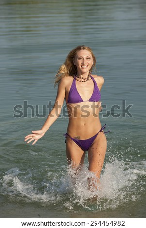 Young woman having fun in the water in hot summer