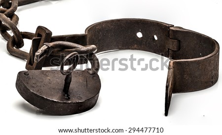 Rusty old shackles with padlock, key and open handcuff used for locking up prisoners or slaves between 1600 and 1800.  Royalty-Free Stock Photo #294477710