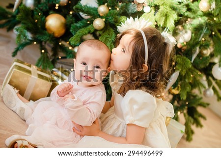 two little girl in Christmas with presents on floor