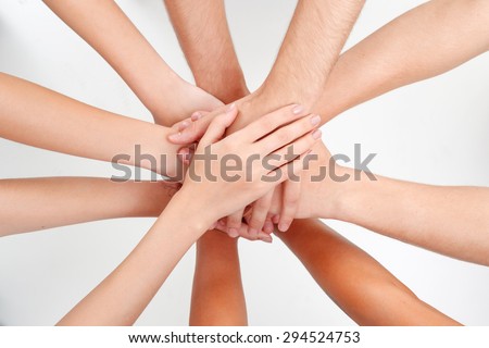 Unity of friends. Portrait of hands of people putting their hands of each other as sign of unity on white isolated background.
