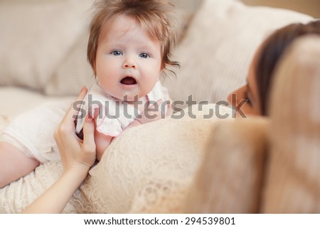 Portrait of a mother with her 4 months old baby at home. Happy child near to mum in her room. Portrait of a mother with her newborn baby.