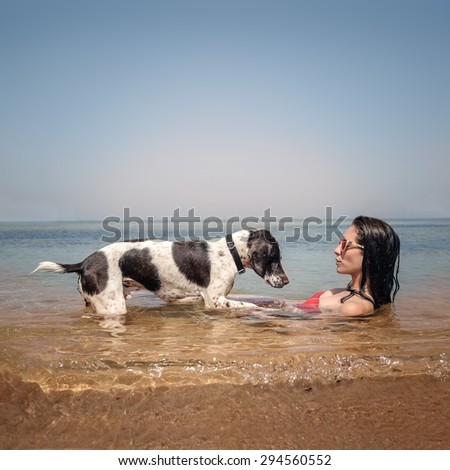 A woman and her dog lying in the water