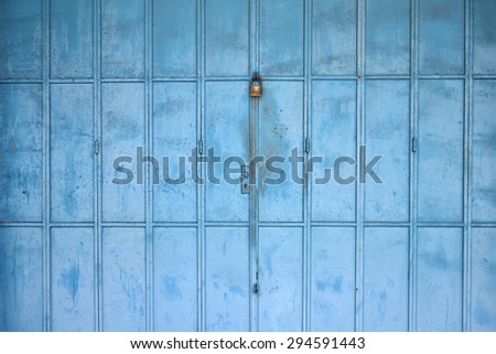 Old blue metal door with padlock. Vintage effect.