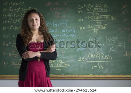 Portrait of a woman in front of a chalkboard in a classroom