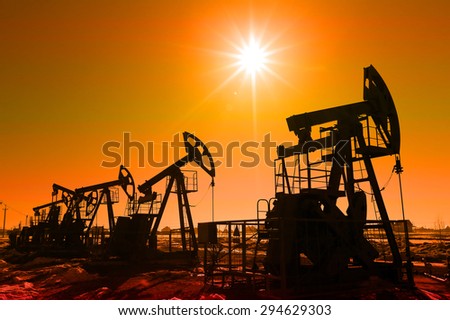industrial landscape oil pumps in the early spring on a blue sky background