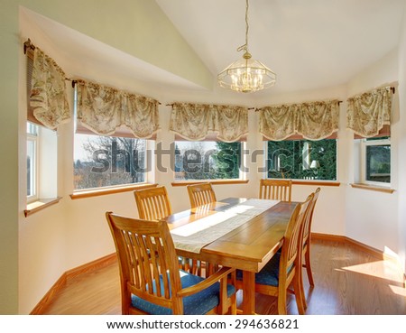 Simple dinning room with hardwood floor and lots of windows.