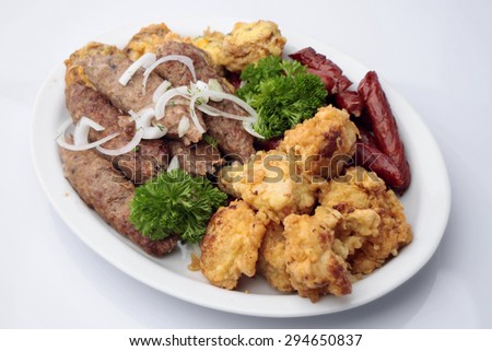 Diner platter of tasty grilled shish kebabs and sausages with fried cauliflower grilled mushrooms stuffed with cheese isolated on white, horizontal picture