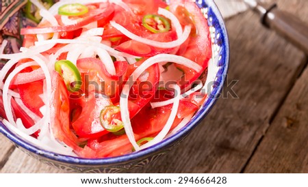 Pilaf and achichuk salad in handmade plate with antique forks on wooden background. Horizontal, wide screen, macro