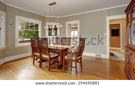 Traditional dinning room with hanging light fixture and windows.