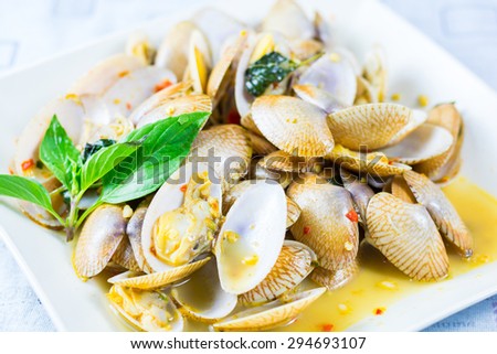 Stir fried clams with roasted chili paste on white dish and white background.Thai food
