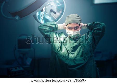 Male surgeon tying mask at operating room Royalty-Free Stock Photo #294785597