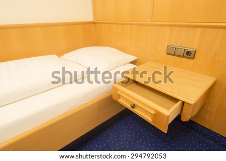 simple clean bedroom fragment with focus on wooden shelf