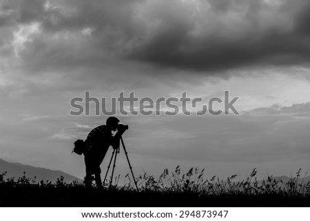 Image black and white, silhouette of a professionell photographer