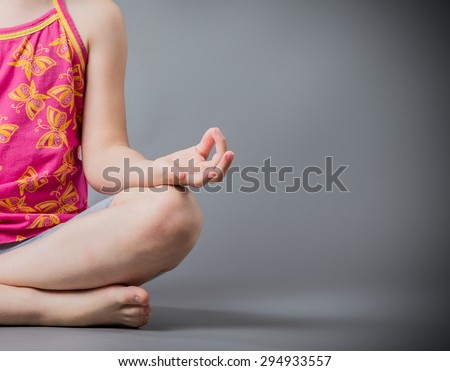The little girl sits in a pose meditation Royalty-Free Stock Photo #294933557