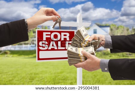 Man Handing Woman Thousands of Dollars For Keys in Front of House and For Sale Real Estate Sign.