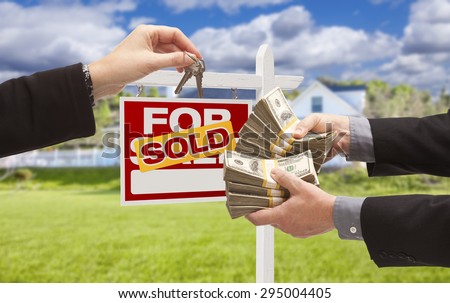 Man Handing Woman Thousands of Dollars For Keys in Front of House and Sold For Sale Real Estate Sign.