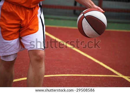 Basketball player running with ball in hand in the court