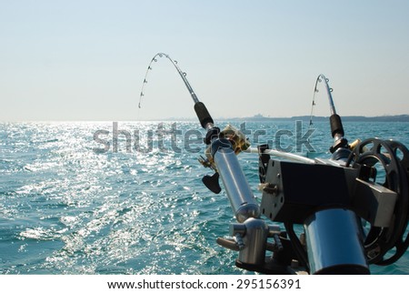 Fishing rods on a boat. Picture of two fishing rods in pole holders on the back of a boat.