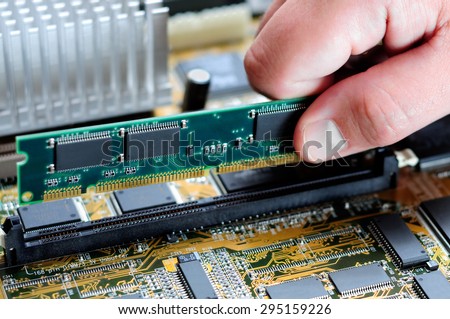 Picture of a person's hand installing memory on a computer motherboard