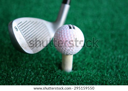Golf club with a ball on a green background
