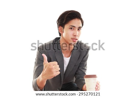 Smiling Asian man drinking coffee.