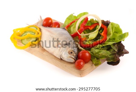 Fresh mackerel fish with vegetables on chopping block isolated on white background