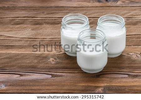 yogurt in glass jars on wooden table at country style