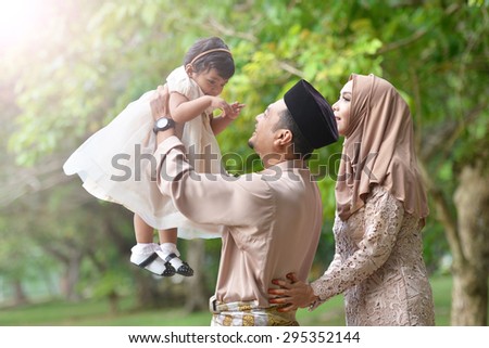 asian family enjoying quality time with father, mother and daughter in park Royalty-Free Stock Photo #295352144
