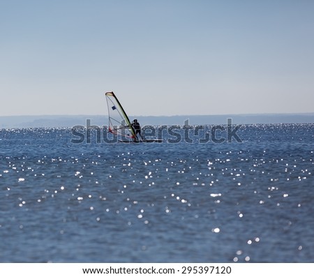 Windsurfers swimming in sea. Summertime photo with windsurfers swimming on water surface