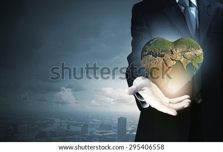 Hand of businessman holding earth planet. Elements of this image are furnished by NASA