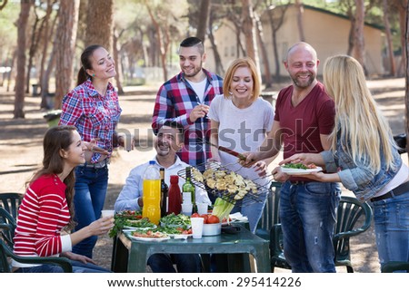 Cheerful friends posing and taking the pictures together at barbecue 
