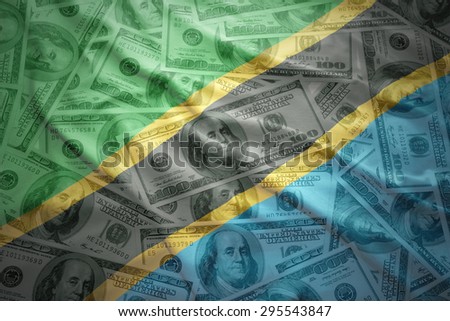colorful waving tanzanian flag on a american dollar money background