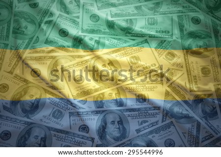 colorful waving gabonese flag on a american dollar money background