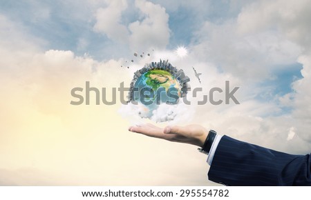 Close up of male hand holding our Earth planet. Elements of this image are furnished by NASA