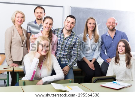 Happy professionals and coach posing at training session school. Focus on girl Royalty-Free Stock Photo #295564538