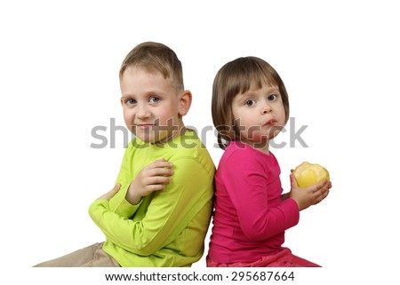 Little boy and girl with apple in hands sitting back to back isolated on white background