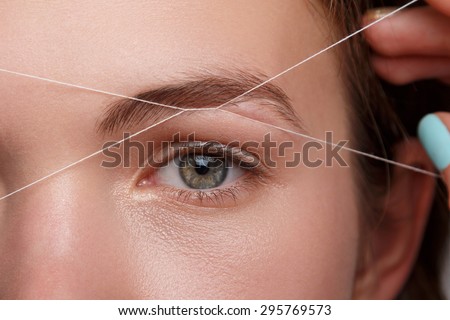 Close-up of female face during eyebrow correction procedure Royalty-Free Stock Photo #295769573